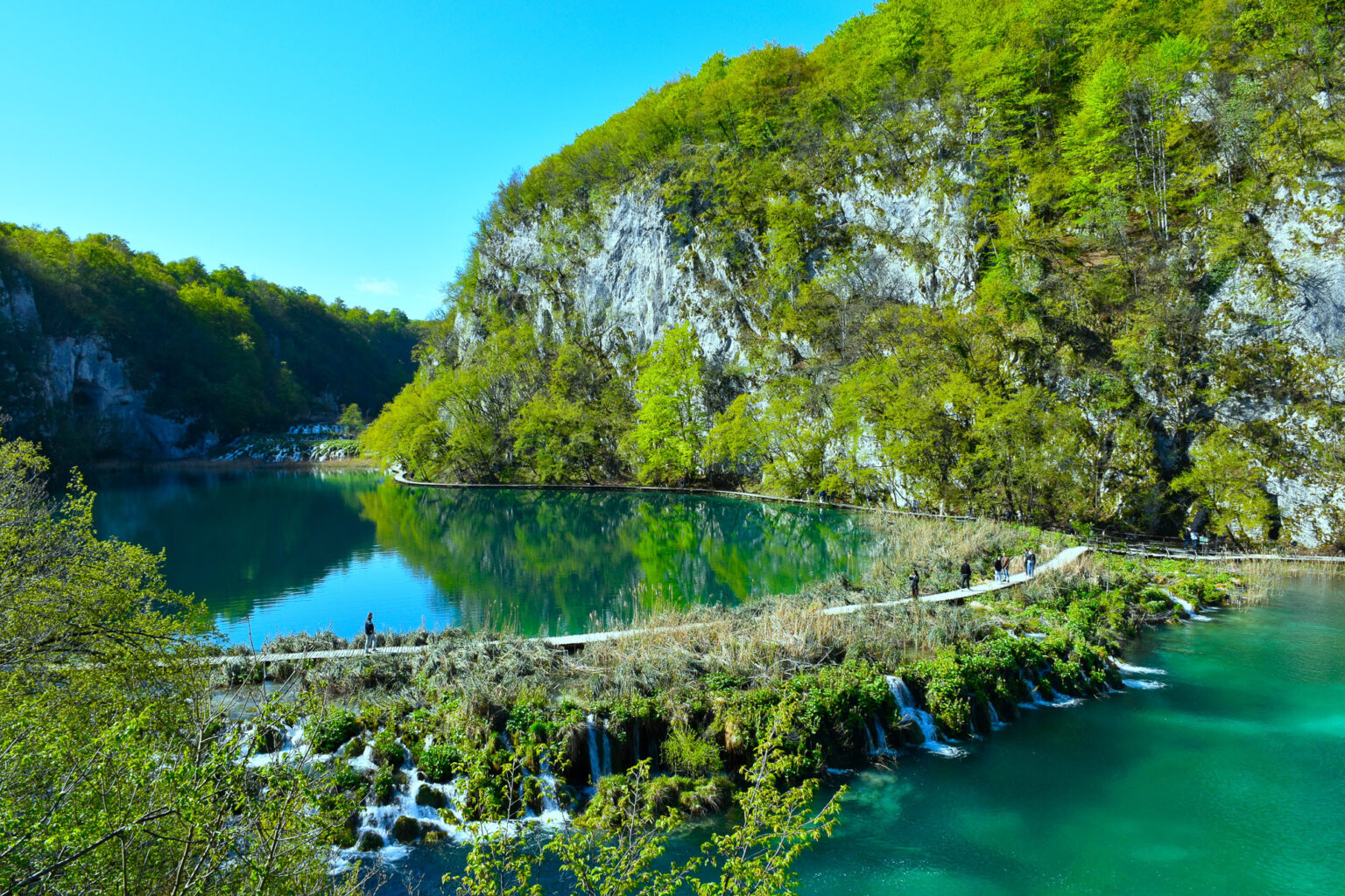 Wooden boardwalk above a waterfall cascade in Plitvice Lakes National Park, Lika, Croatia