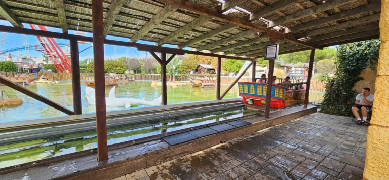 Colourful boats on a water ride beneath a wooden shelter at an amusement park in Croatia