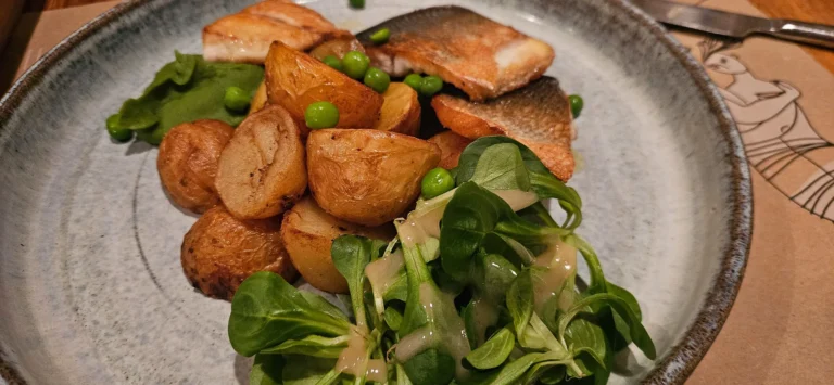 Seared fish with roasted potatoes, peas and leafy greens in Croatia.