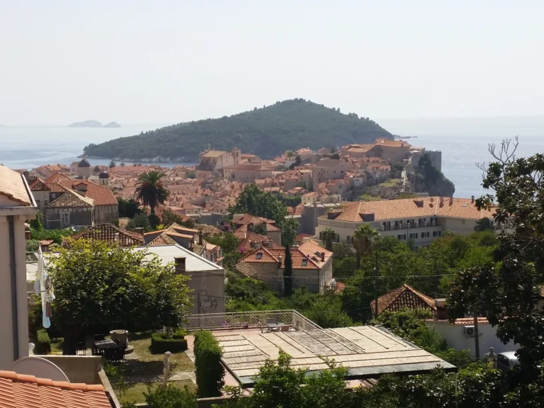 Dubrovnik’s terracotta-roofed Old Town viewed from above, with Lokrum Island beyond the coast