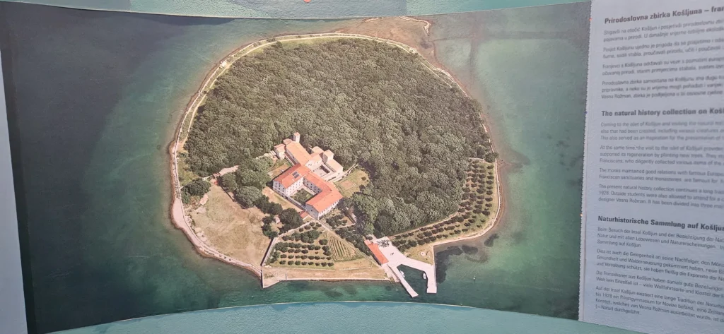 Aerial view of Košljun Island and its monastery displayed on a natural history exhibit panel