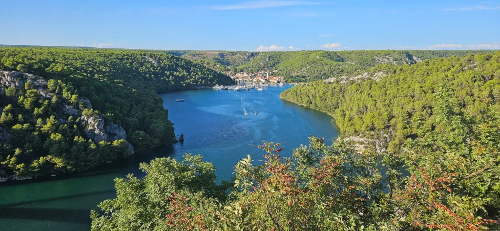 Lim Bay winds between forested hills, with boats and buildings clustered at the far end.