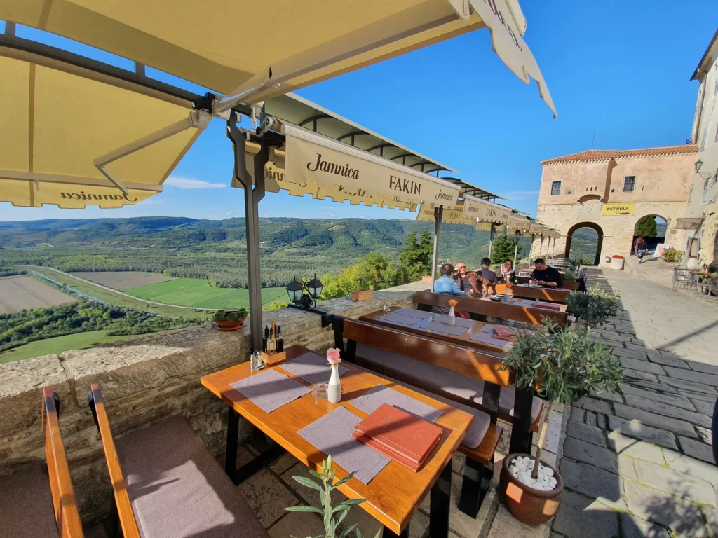 Outdoor dining terrace in Motovun with a view across the green Mirna Valley.