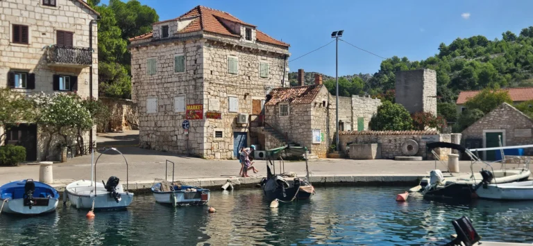 Small boats moored beside a stone village waterfront on the Croatian coast