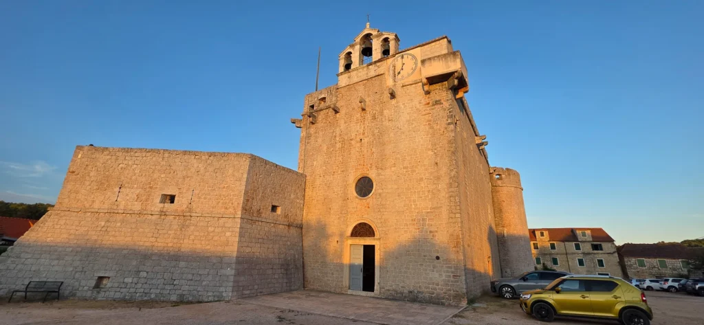 The stone fortified church in Vrboska, with its clock tower glowing in warm evening light